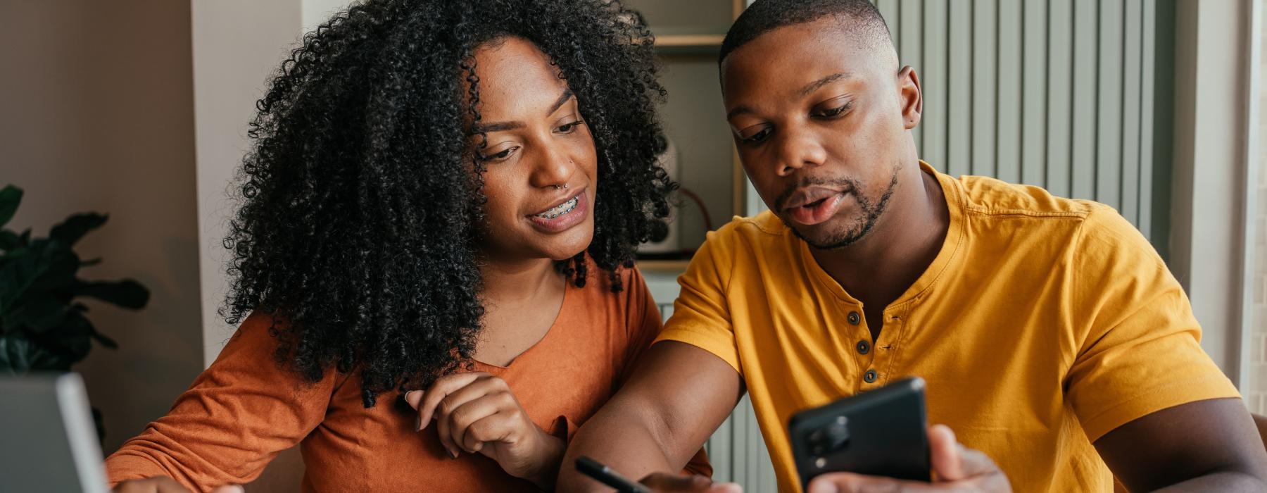 a man and a woman looking at a phone