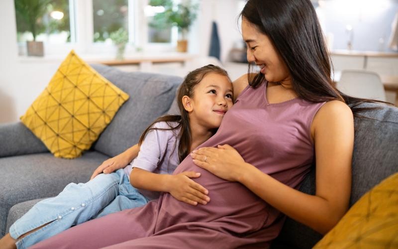 a woman and a girl sitting on a couch