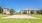 a large house with a lawn and trees in front of it